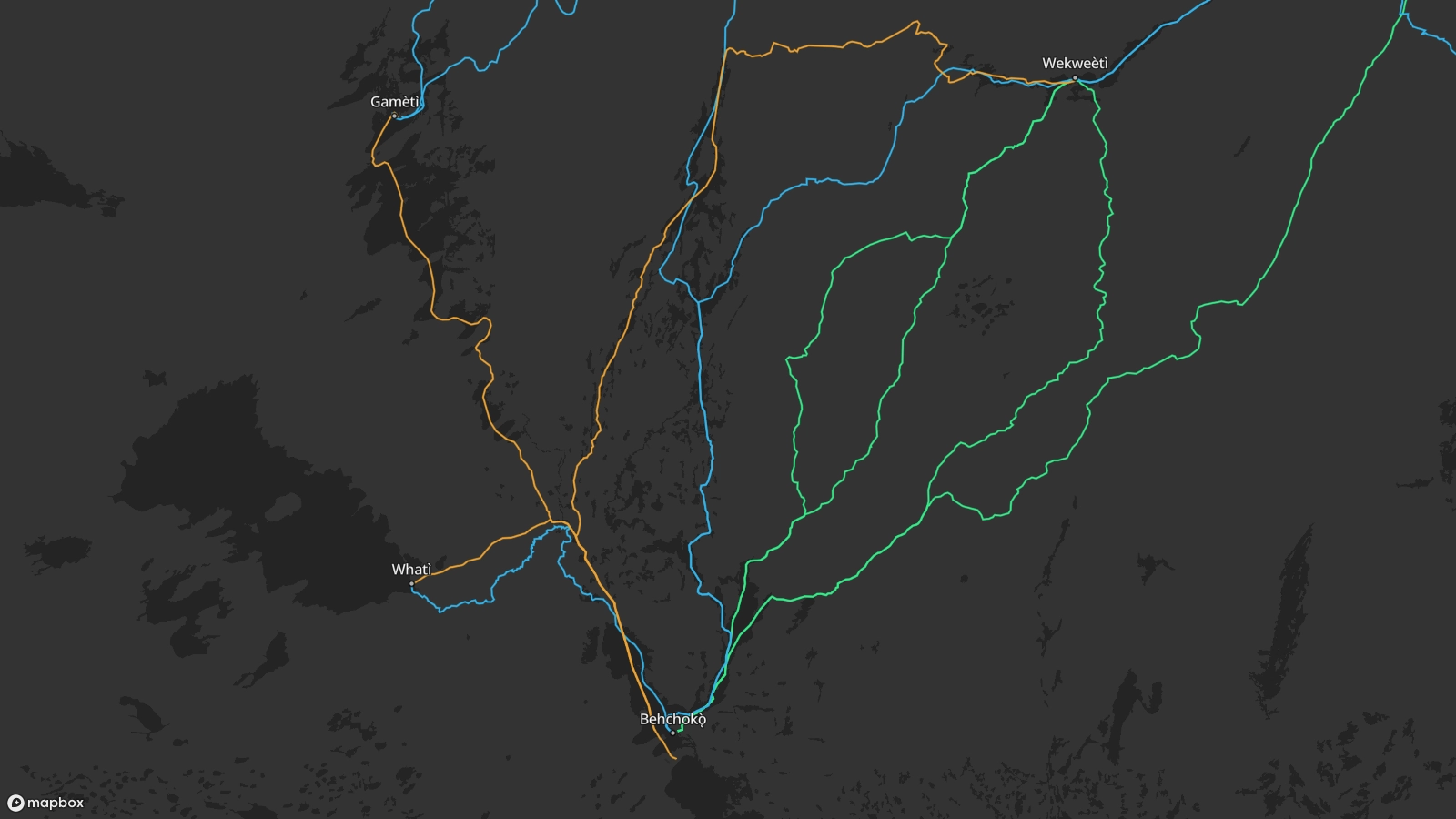 Map showing the traditional trails linking the Tłı̨chǫ communities of Behchokǫ̀, Whatì, Gamèti, and Wekweėti. Yellow trails are marked to indicate roads used in the winter when the lakes and rivers freeze over. Blue trails are marked to indicate trails that follow the natural path of rivers between communities. Green trails are marked to indicate the paths that dog sled teams travel from Behchokǫ̀ to Wekweėti.